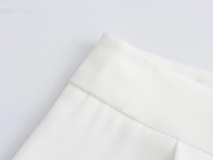 Close-up of white elegant wide-leg trousers waistband with detailed twill fabric texture