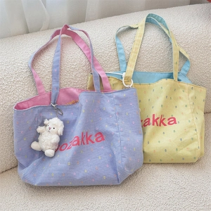 Close-up of contrast plaid canvas tote bags with ozakka embroidery and plush lamb charm