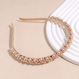Detailed close-up of an elegant pearl headband with mixed size beads on a satin base