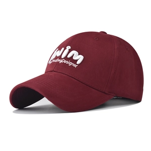 Macro shot of 3D white embroidery on a burgundy washed cotton baseball cap brim