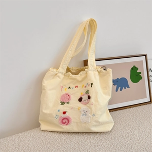 Detail of cute Peach Puppy embroidery and patches on a light yellow canvas tote bag