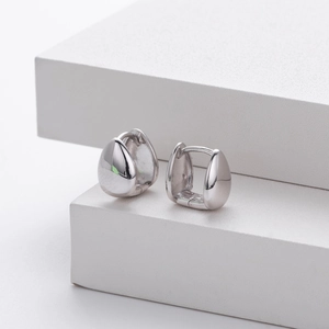 Minimalist S925 sterling silver drop-shaped earrings with a polished finish on white steps
