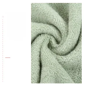 Macro detail of soft light green cotton bath towel with spiral fiber texture weave