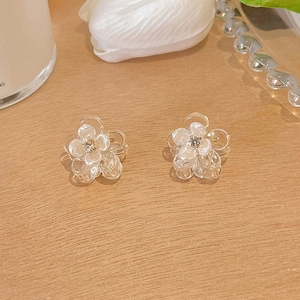 Elegant floral mini hair claws with rhinestones on a rustic wooden surface backdrop