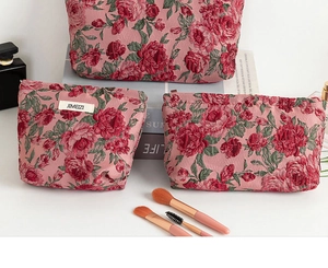 Dettaglio del set di tre borse da toilette rosa a fiori jacquard con etichetta JIMEIZI