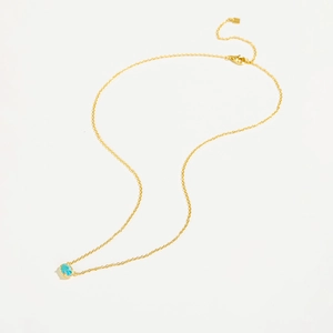 Detailed view of an oval blue glass stone pendant on a dainty 925 sterling silver gold chain