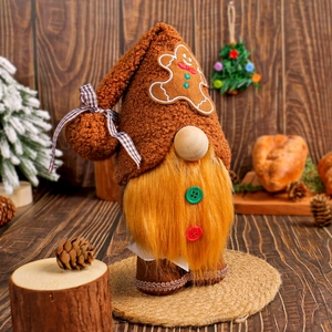 Plush Christmas gnome ornament with ginger man hat and yellow beard on wooden background