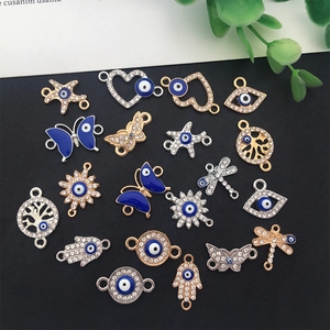 Flat lay of evil eye charms including butterfly and heart shapes for DIY jewelry making