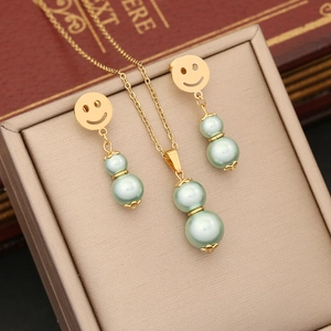 Elegant gold-plated jewelry set with mint green double pearls on a vintage display box