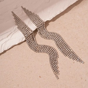 Detailed view of silver crystal tassel earrings with sparkling rhinestone waves