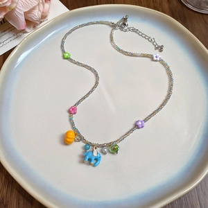 Detail of colorful beads and cute elephant charms on a stainless steel flower necklace
