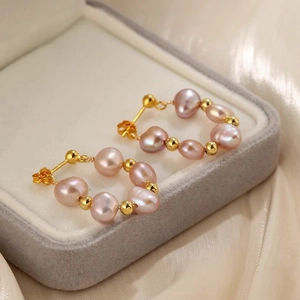 Detail of pink baroque pearls and gold beads on a circular hoop earring design