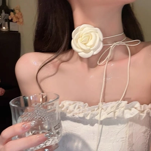 Detail shot of a large 3D white fabric rose choker with long adjustable ribbon ties