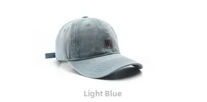 Close-up of red letter W embroidery on light blue denim fabric of a baseball cap