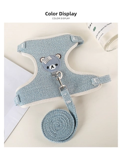 Detail of light blue woven pet harness and leash set with a bear patch on cream table