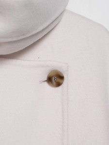 Macro view of off-white wool blend fabric texture with a brown marble resin button