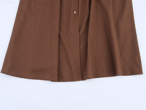 Detailed macro view of dark brown linen-like fabric with silver metal snap button