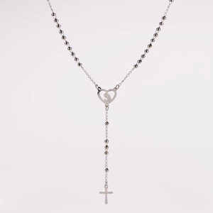 Detail einer silbernen Rosenkranzkette mit Herz-Marienanhänger und schlichtem Kreuzanhänger