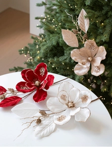 Close-up of velvet artificial magnolia flowers with gold glitter and pine cone accents