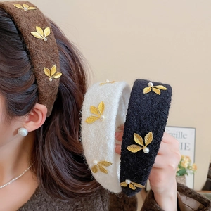 Detail of velvet padded headband with gold leaf embroidery and pearls in vintage style