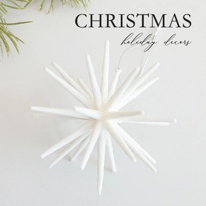 Sparkling white star Christmas ornament with glitter coating on pine branch background