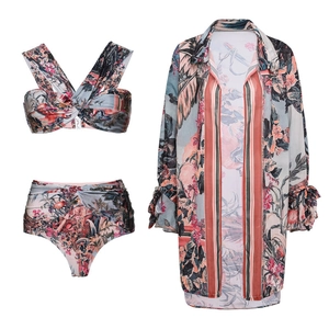 Detailed flat lay of three-piece vintage floral bikini set with matching long sleeve cover-up