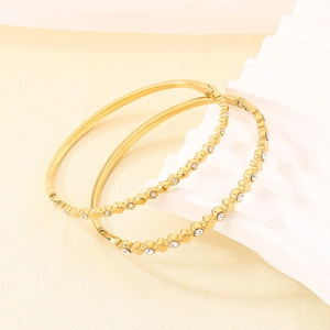 Dettaglio di bracciali in acciaio inossidabile placcato oro 18K con zirconi bianchi