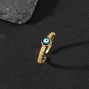Macro detail of gold adjustable evil eye ring with blue enamel and pavé zircon stones