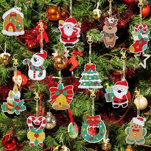 Close-up of 12 DIY Christmas diamond painting keychains hanging on a festive decorated tree