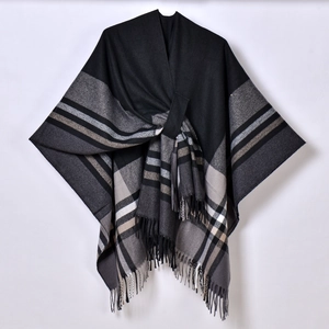 Close-up of tassel fringe hem and jacquard plaid pattern on knitted shawl cape