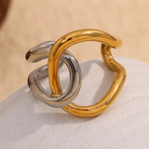 Macro detail of intertwined gold and silver two-tone irregular polished metal ring