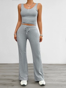 Detail view of grey yoga set with button-up crop top and drawstring wide leg trousers