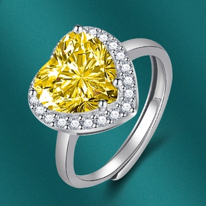Détail d'une bague avec pierre jaune en forme de cœur et anneau réglable en argent