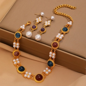 Macro detail of vintage gold-plated necklace with faux pearls and colorful resin inlays
