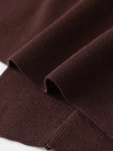 Close-up detail of dark brown knit fabric texture showing premium weave and soft quality