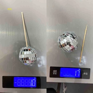 Detailed comparison of 4cm and 5cm disco mirror ball cake toppers on an electronic scale