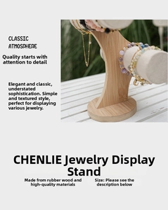Three-tier bamboo jewelry display stand with velvet cylinders on a white wooden table