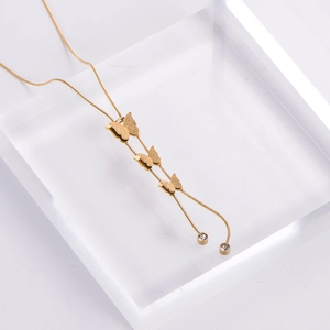 Detail of gold double-layer necklace with frosted butterflies and tassel rhinestones