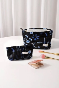 Close-up of black cotton-linen makeup bags with blue floral embroidery and zipper
