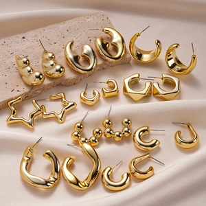 Detail of 20-piece gold geometric earring set displayed on light stone and silk fabric