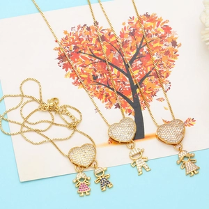 Detail of gold heart necklaces featuring zircon-studded boy and girl charms