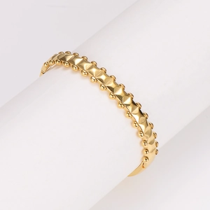 Vintage stainless steel wavy gold bangle with geometric studs and crystal accents