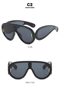 Futuristic oversized black wrap-around sunglasses with sleek gold metal temple accents
