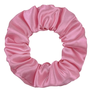 Detail shot of smooth pink satin fabric and elastic pleats on the large hair scrunchie