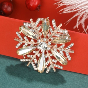 Detail of snowflake brooch with amber crystals on red gift box with festive decor