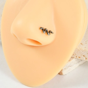 Détail macro d'un piercing de nez en titane argenté en forme de serpent sur un modèle
