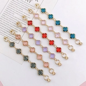 Macro detail of six clover bracelets in various colors with gold-plated alloy base
