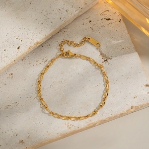 Detailed close-up of 18K gold-plated stainless steel chain link bracelet with S.Steel tag
