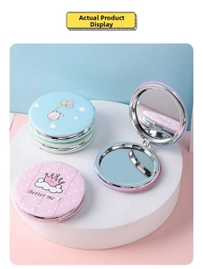 Detailed view of portable folding makeup mirror with pastel colors and crown pattern