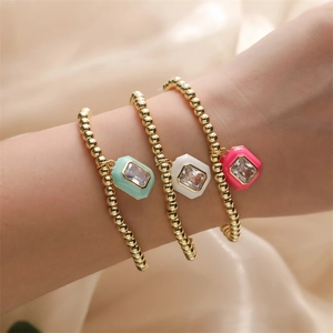 Three gold beaded bracelets with mint green, white and pink square gemstone charms